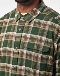 Men's plaid flannel shirt in green and brown tartan, chest pocket detail close-up