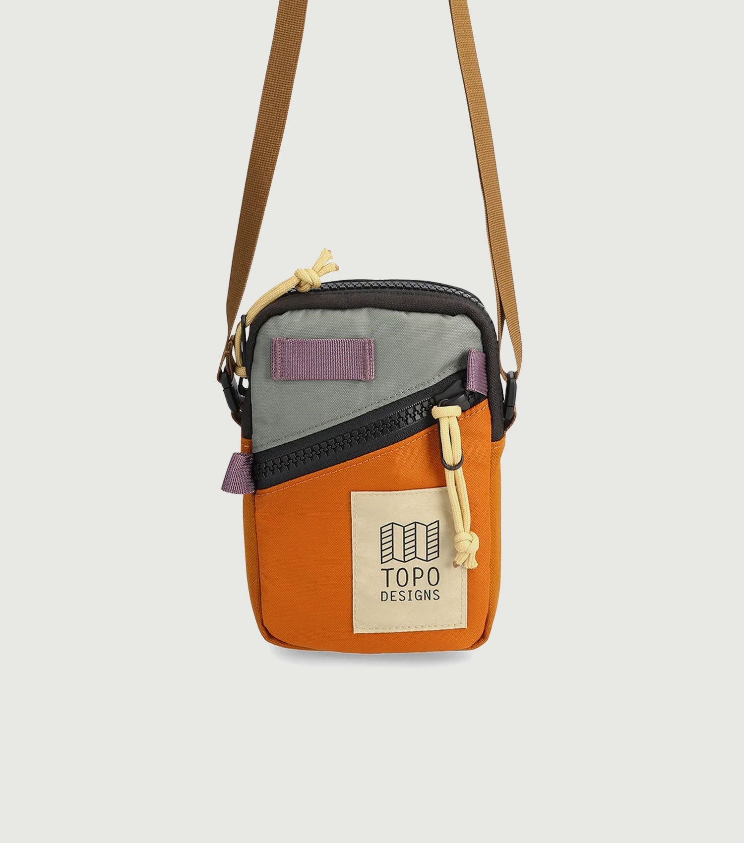 Small crossbody bag with colorblock design featuring orange base, gray top panel, and adjustable shoulder strap