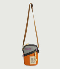 Small crossbody bag with orange and gray colorblock design and brown adjustable strap