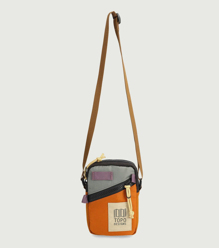 Small crossbody bag with orange and gray colorblock design and brown adjustable strap