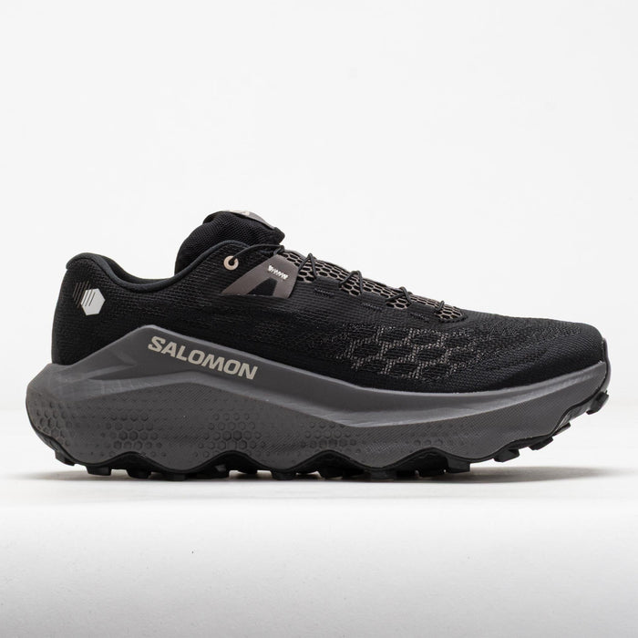 Black trail running shoe with chunky gray midsole and aggressive lug outsole, lateral view