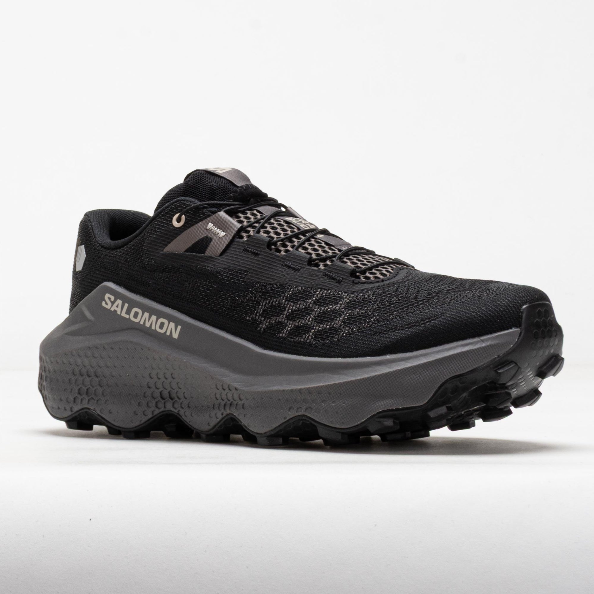 Black trail running shoe with chunky gray midsole and aggressive lug outsole, side view