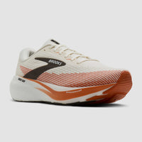 Running shoe with cream upper, orange gradient detailing, chunky white midsole, three-quarter front view