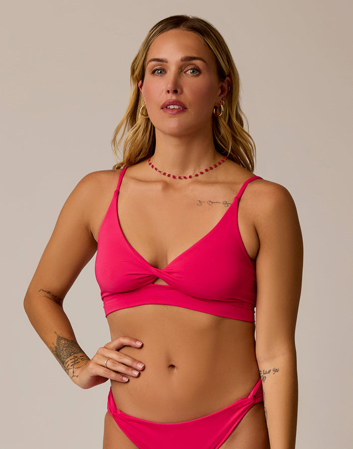 Women's triangle bikini top in bright pink with twist front detail and thin straps, front view
