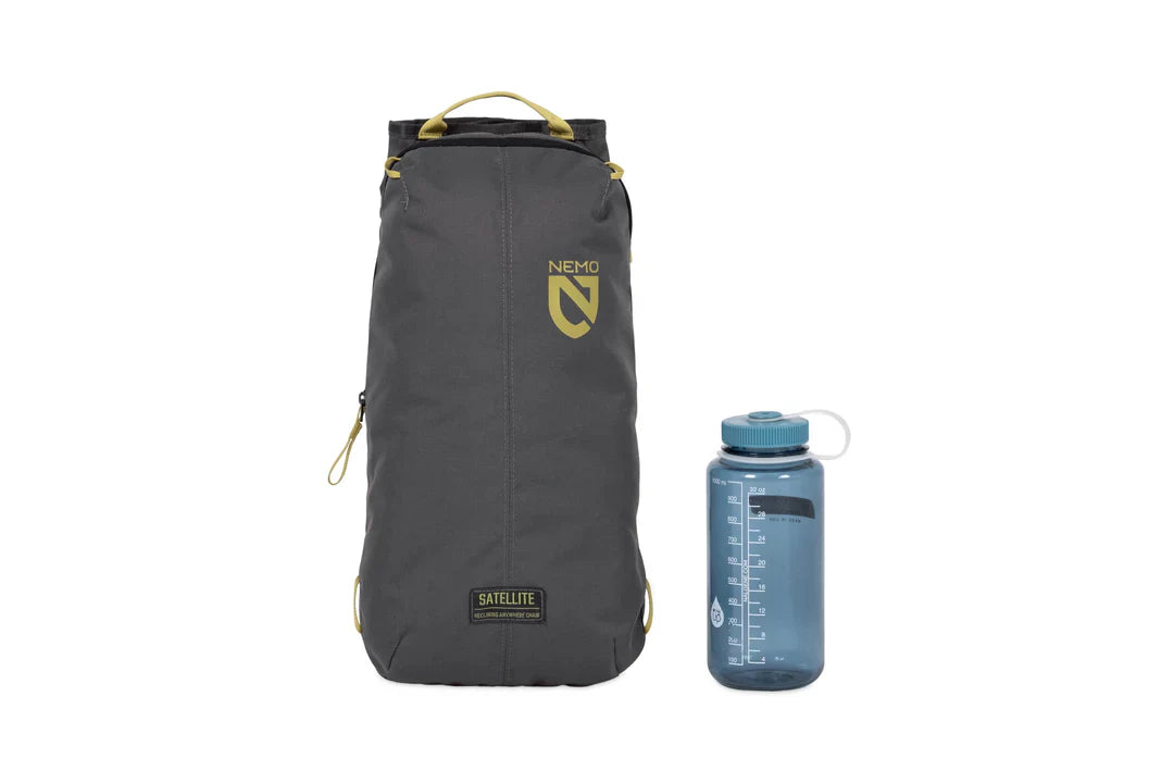 Packed reclining chair in dark grey stuff sack with olive accents, shown beside a water bottle for scale