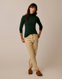 Women's long-sleeve turtleneck in dark green, fitted silhouette, full front on-model view