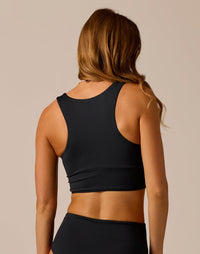 Women's black sleeveless crop top with racerback design, rear view on model