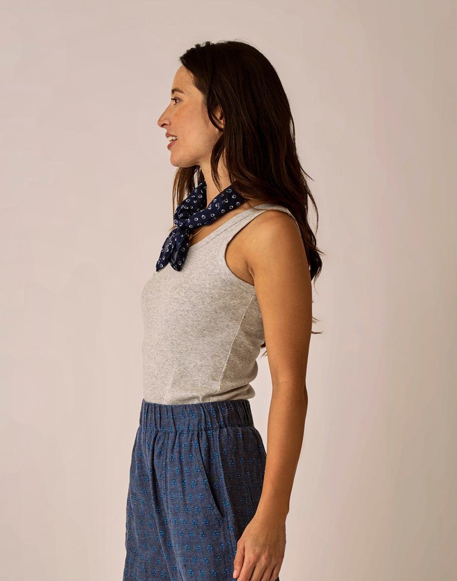 Grey ribbed sleeveless tank top worn with navy patterned bottoms, side profile view