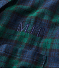 Close-up detail of plaid flannel robe chest pocket with embroidered monogram initials MJT