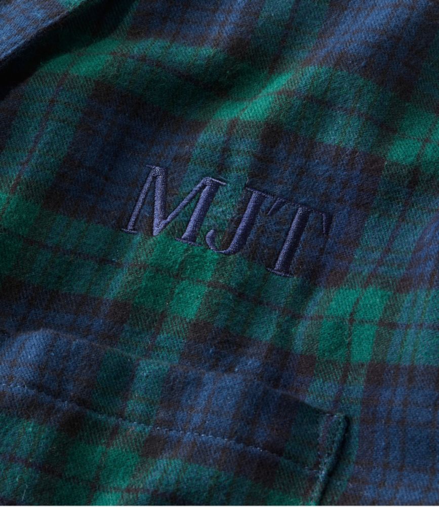 Close-up detail of plaid flannel robe chest pocket with embroidered monogram initials MJT