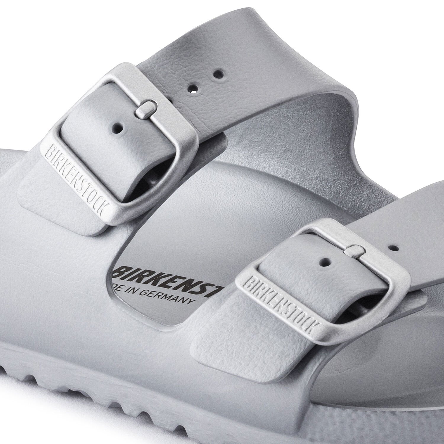 Metallic silver two-strap sandals with adjustable buckles and textured sole, angled view