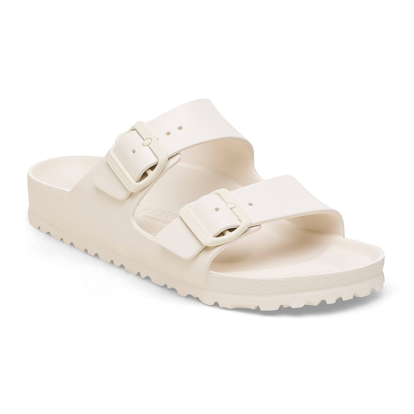 Cream colored dual-strap sandals with adjustable buckles and textured sole