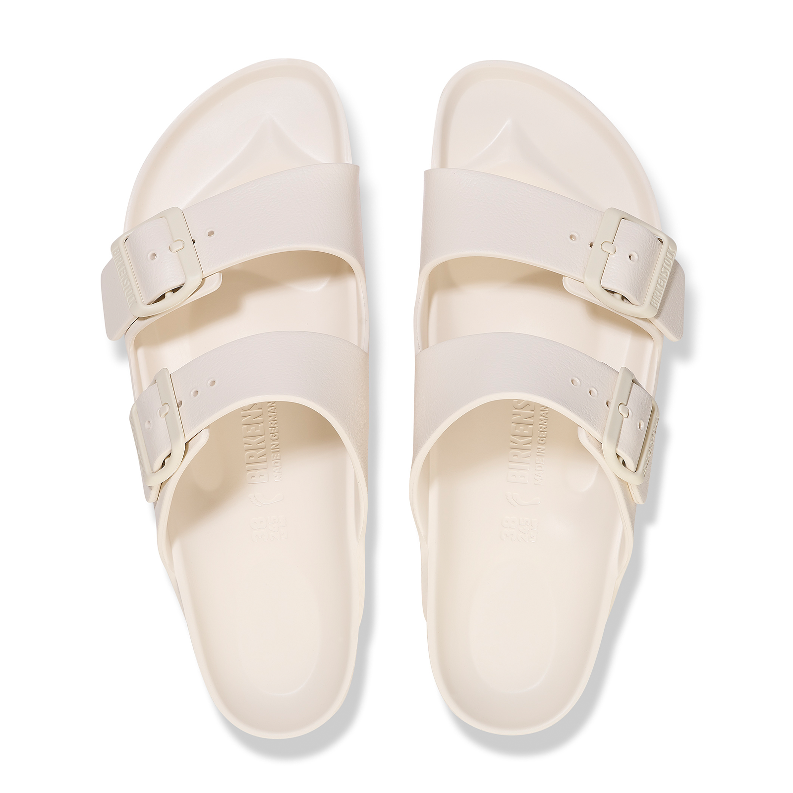 Pair of light beige two-strap sandals with adjustable buckles, top-down view