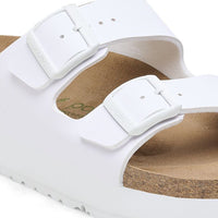 White two-strap sandals with buckles and cork footbed, angled view