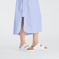 White platform sandals with two adjustable straps worn with blue dress