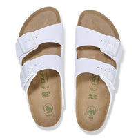 White two-strap slide sandals with adjustable buckles and cork footbed, top view