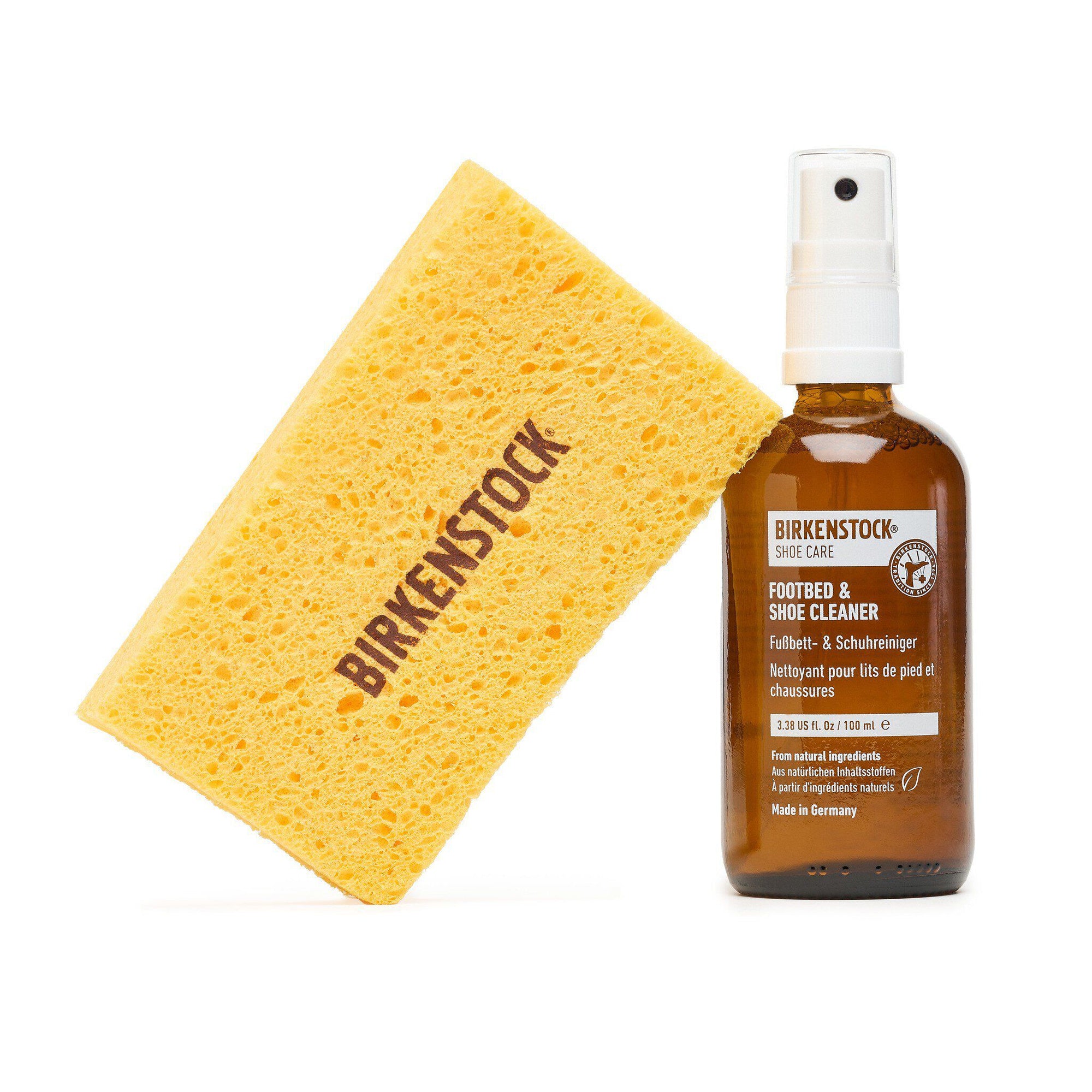 Shoe cleaning spray bottle with pump dispenser and yellow cleaning sponge on white background
