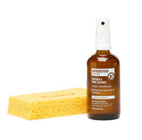 Amber spray bottle of shoe cleaner with yellow cleaning sponge on white background