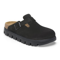 Black suede closed-toe clog with side buckle strap and chunky lug sole, angled view