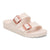 Two-strap slip-on sandals in light pink with rose gold buckles on white background