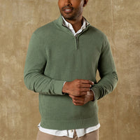 Man wearing sage green quarter-zip sweater over white collared shirt