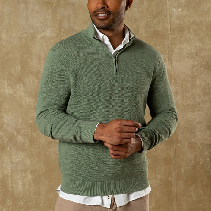 Man wearing sage green quarter-zip sweater over white collared shirt