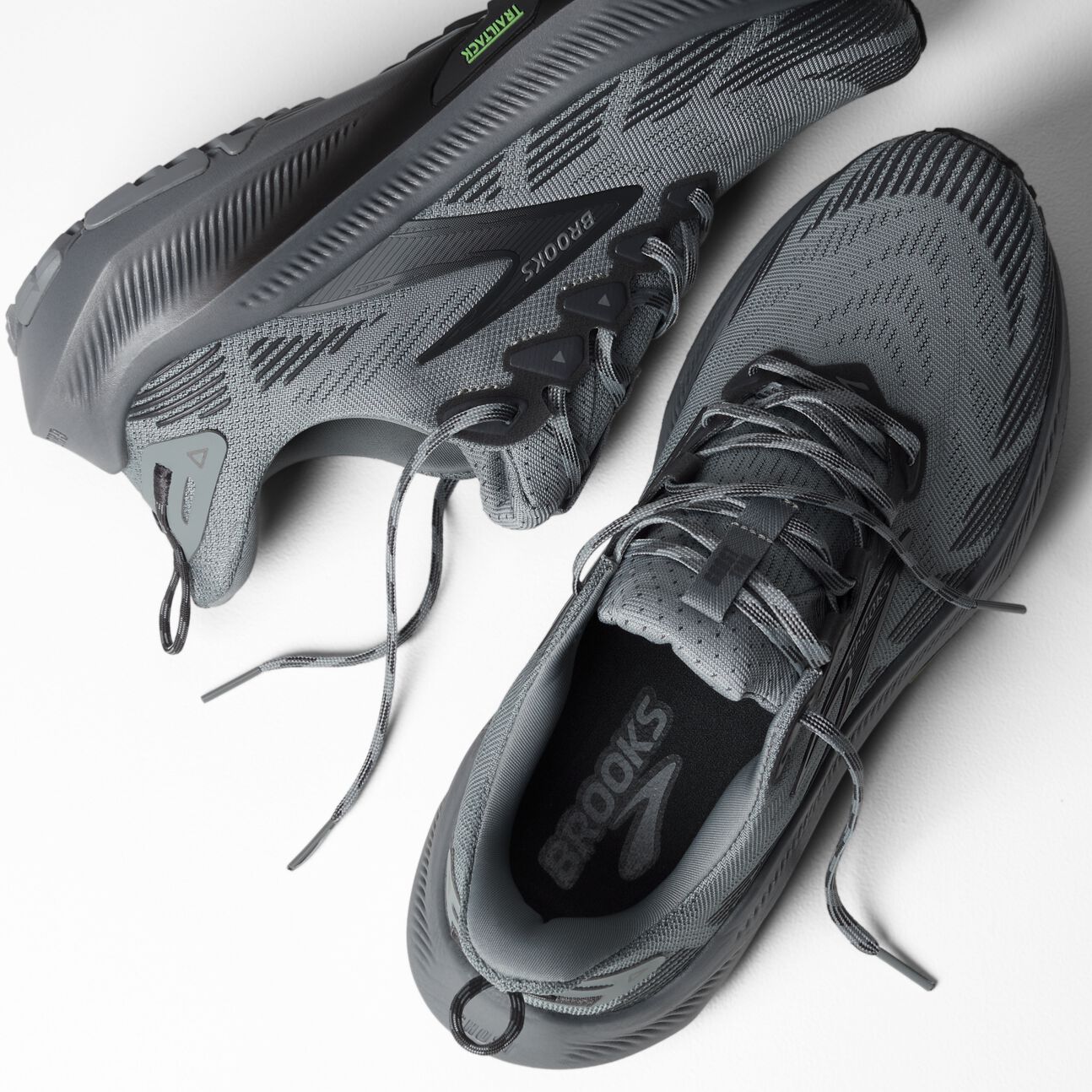 Gray trail running shoes with black laces and textured outsole, overhead view