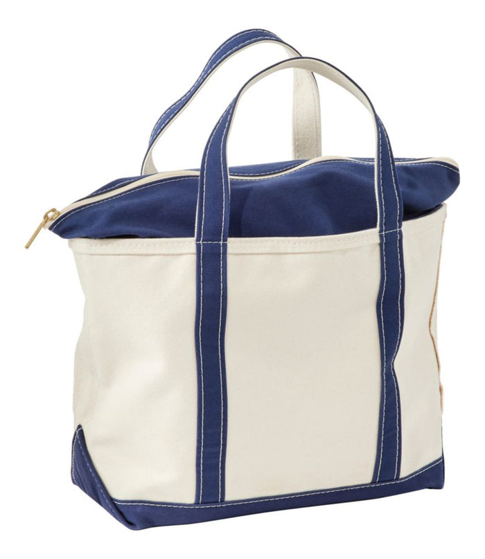 Large canvas zip-top tote bag with navy blue handles, trim, and zipper closure, angled view