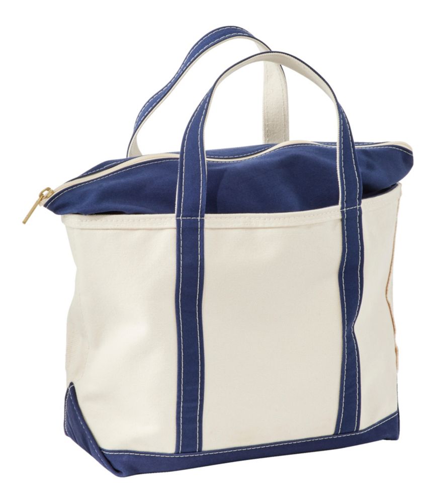 Large canvas zip-top tote bag with navy blue handles, trim, and zipper closure, angled view