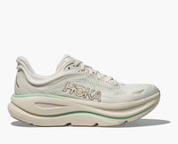 Light colored running shoe with mesh upper and thick cushioned sole, side profile view