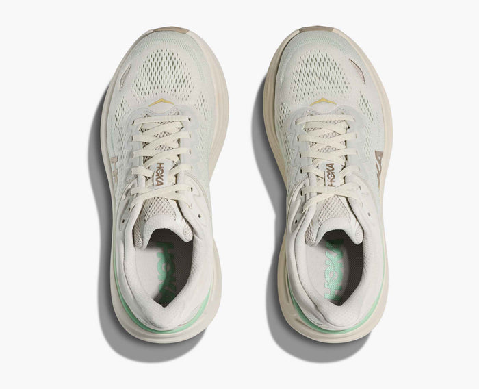 Light colored running shoes with mesh upper, top-down view showing laced design and breathable construction