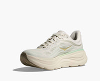 Light beige running shoe with mint green stripe and thick cushioned sole, side angle view