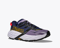 Trail running shoe in navy blue and purple colorway with white midsole, side view