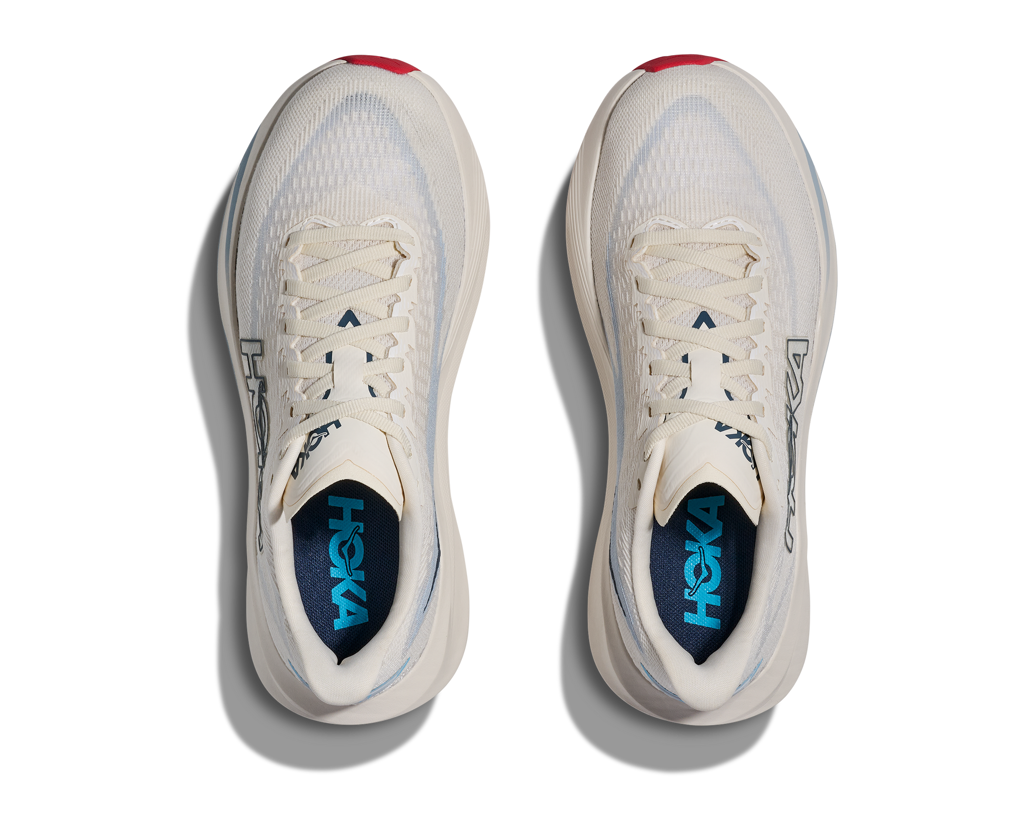 Pair of light colored running shoes with mesh upper, top-down view showing laces and insoles