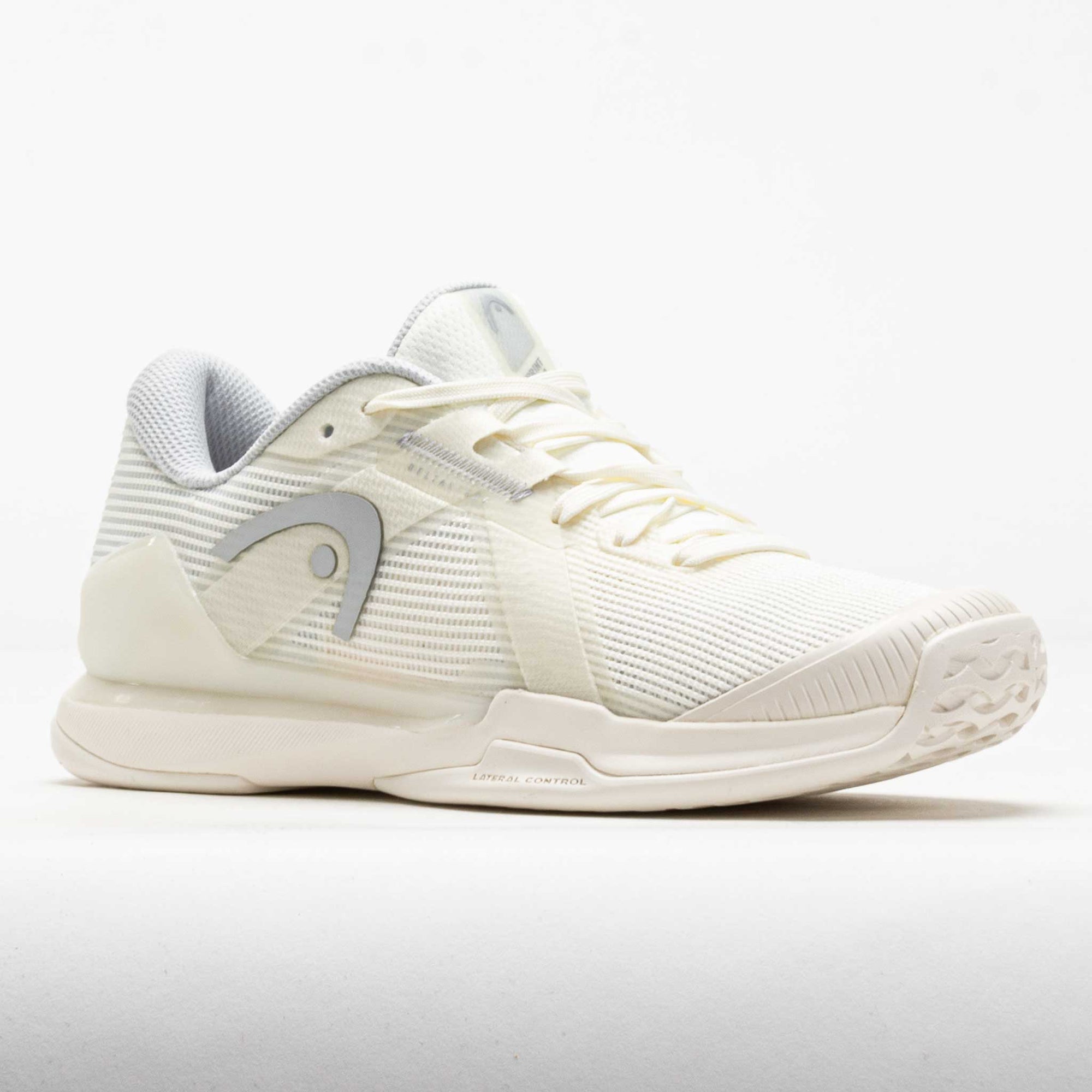 Women's tennis shoe in off-white with grey accents, three-quarter front view showing mesh upper