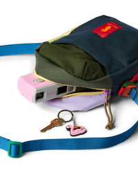 Colorblock crossbody shoulder bag open showing pink camera, keys with flamingo keychain nearby