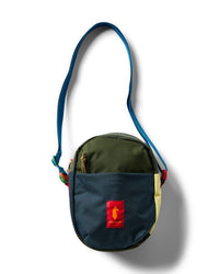 Small round crossbody shoulder bag with multicolor patchwork panels, zippered front pocket, blue strap