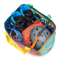 Large multicolored duffel bag packed with outdoor gear including helmet, boots, and climbing equipment