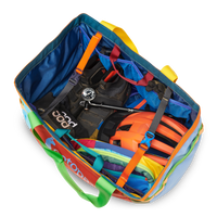 Open multicolored duffel bag showing packed gear including life vest, compass, and other outdoor equipment
