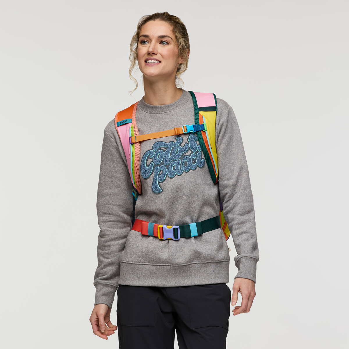 Multicolored travel backpack with rainbow striped pattern and adjustable straps, front view