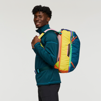 Colorful patchwork travel backpack with multiple bright fabric panels worn by model