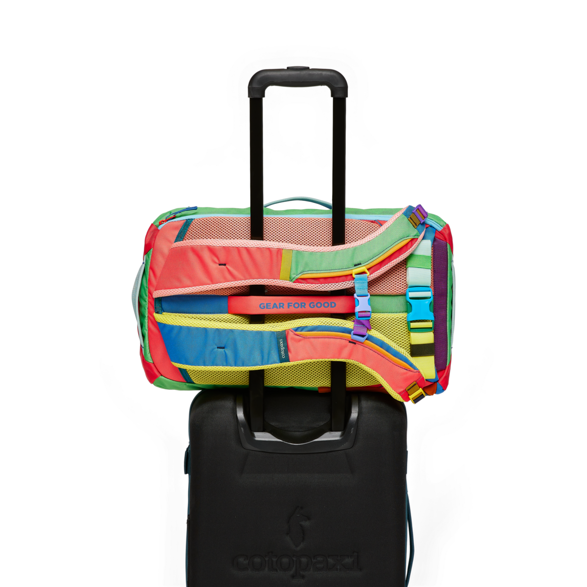 Multicolored travel backpack with colorful patchwork panels on rolling suitcase handle