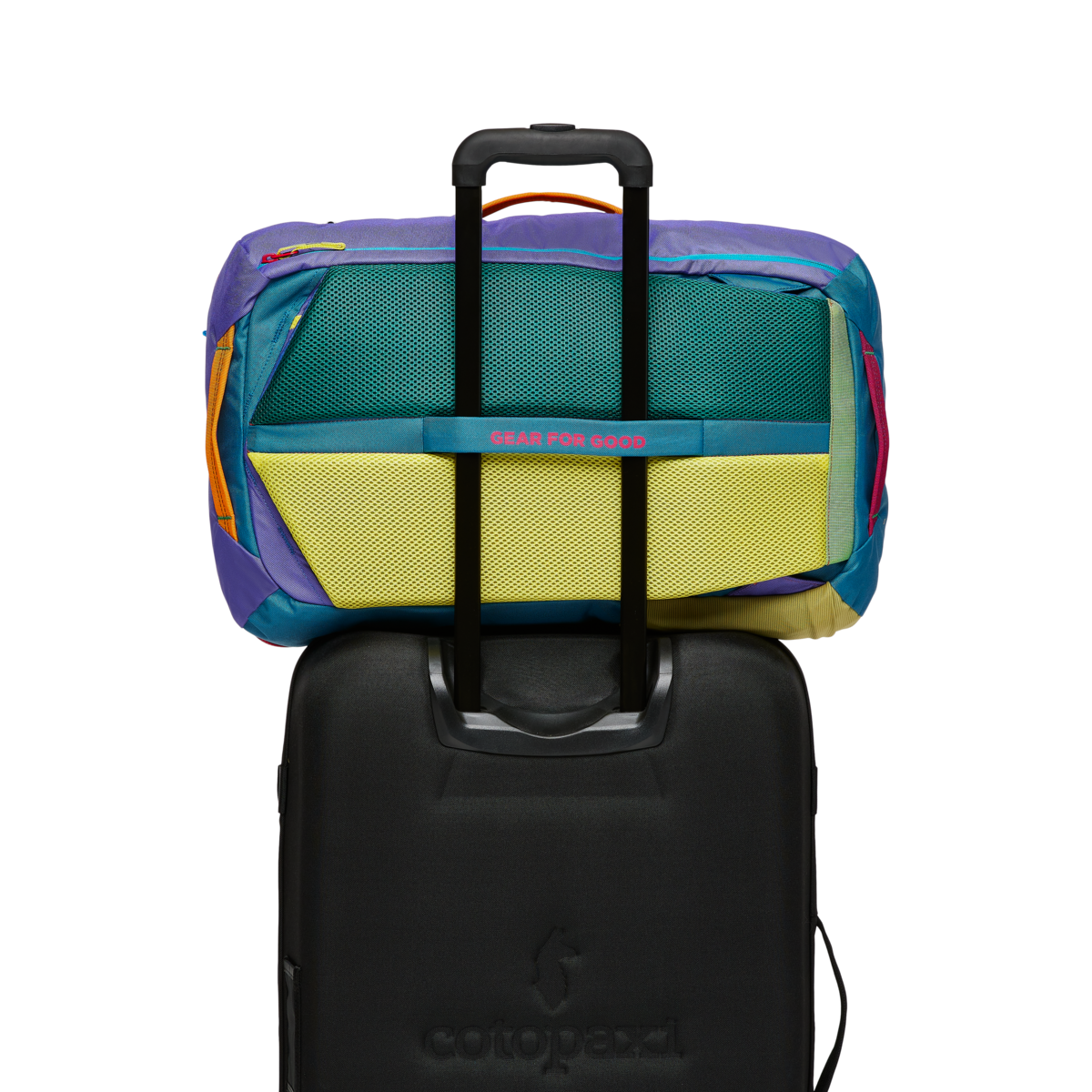 Colorful travel backpack with multiple mesh compartments open, shown on black wheeled luggage
