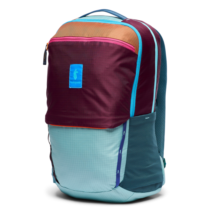 Colorful daypack backpack with burgundy top, teal bottom, orange accent panel, front three-quarter view