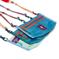 Three colorful crossbody bags with rope straps, zippers, and carabiner clips, stacked together