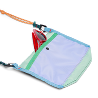 Small crossbody bag open showing red sunglasses inside, with orange rope strap and carabiners