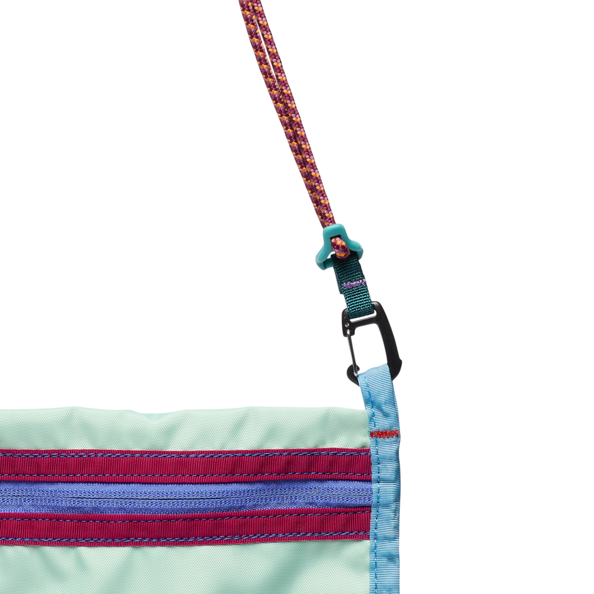 Close-up of crossbody sachet bag with mint fabric, striped zipper detail, and carabiner clip connector
