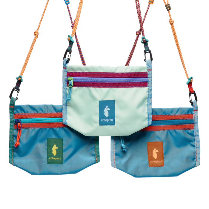 Three small crossbody bags in varied blue tones with colorful zipper accents and rope straps
