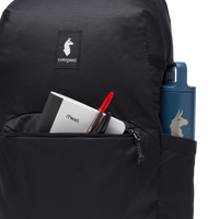 Close-up of black backpack front pocket with notebook, pen, and blue water bottle