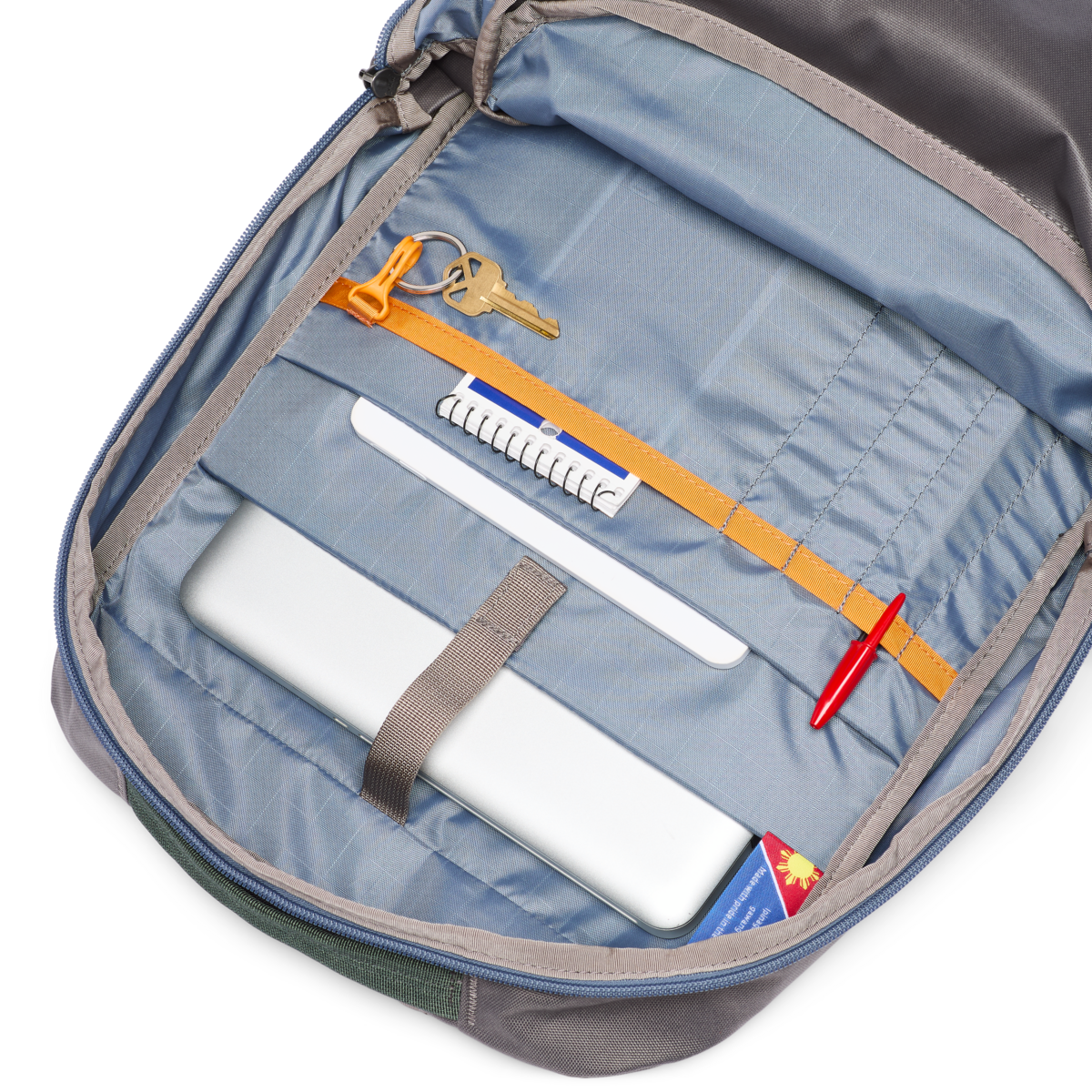 Interior view of 26L backpack showing organized compartments with keys, pen, and accessories